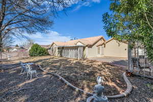 Back of house featuring a tiled roof, fence, and stucco siding