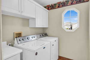 Laundry room featuring cabinet space and washer and clothes dryer