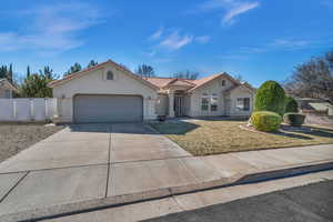 View of front of home featuring a tile roof, stucco siding, an attached garage, fence, and driveway