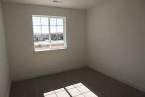 Spare room with carpet, visible vents, and baseboards