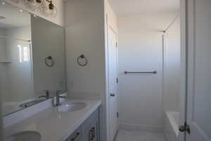 Bathroom featuring marble finish floor, a sink, baseboards, and double vanity