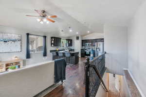 Interior space with lofted ceiling, dark wood finished floors, and baseboards