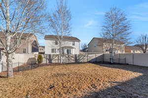 Back of property with a yard, a fenced backyard, and a residential view