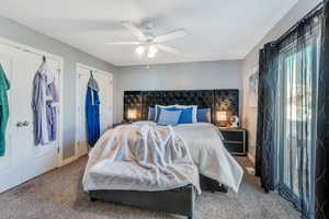 Carpeted bedroom featuring a ceiling fan and baseboards