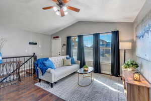 Living room with lofted ceiling, baseboards, and wood finished floors