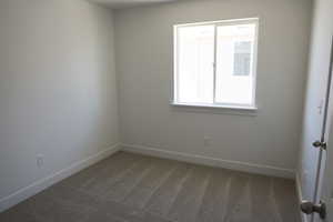 Empty room featuring carpet floors and baseboards