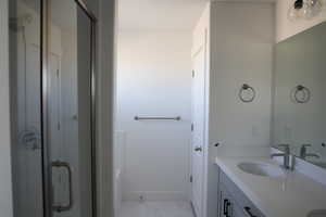 Full bath with a shower, marble finish floor, vanity, and baseboards