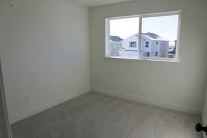 Carpeted spare room with baseboards
