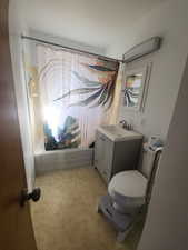 Full bath with toilet, shower / bath combination with curtain, and vanity