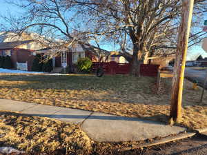 View of front of house with brick siding, a front yard, and fence