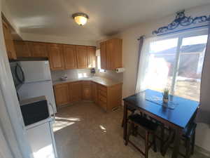 Kitchen with light floors, electric range, and freestanding refrigerator