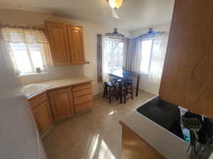 Kitchen featuring electric stovetop, light countertops, and a sink