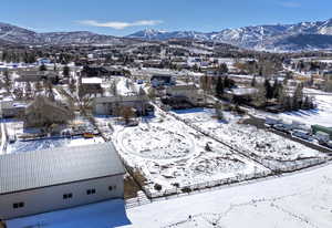 Snowy aerial view featuring a mountain view and a residential view