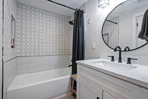 Bathroom with vanity and shower / tub combo with curtain