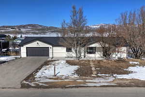 Ranch-style home featuring metal roof, an attached garage, a mountain view, brick siding, and a standing seam roof