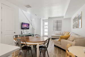 Dining space with light wood-style flooring and visible vents