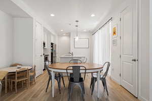 Dining room with light wood finished floors and recessed lighting