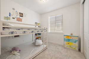 Bedroom featuring light colored carpet, visible vents, and baseboards