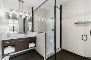 Full bath featuring tile patterned flooring, a shower stall, and vanity