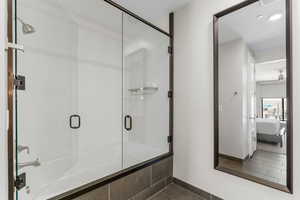 Ensuite bathroom with tile patterned floors, baseboards, connected bathroom, and a shower with shower door