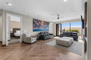 Living room featuring ceiling fan, baseboards, and recessed lighting