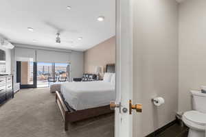 Carpeted bedroom featuring access to exterior, baseboards, a ceiling fan, and a wall mounted AC