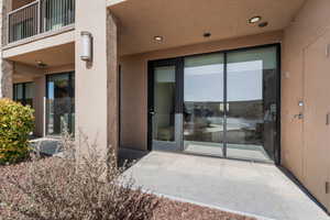 Property entrance featuring a balcony and stucco siding