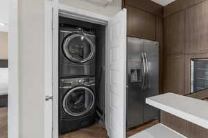 Laundry closet in kitchen area with stacked washer and dryer