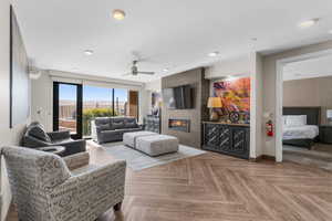 Living room with ceiling fan, a fireplace, and baseboards