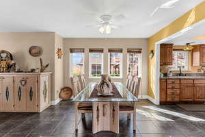 Dining room with a ceiling fan and baseboards