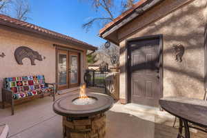 View of exterior entry featuring a tiled roof, french doors, and a patio area