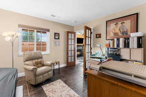 Office area with baseboards, visible vents, a textured ceiling, and french doors