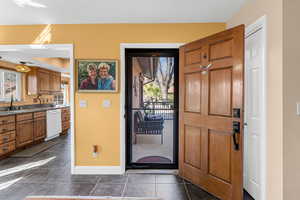 Entrance foyer with baseboards and dark tile patterned flooring