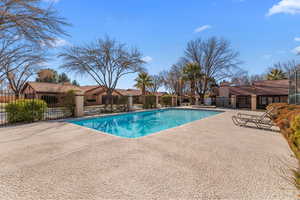 Community pool featuring a patio area and fence