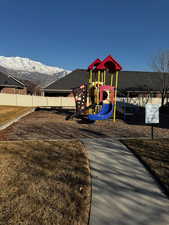 Community play area featuring fence and a mountain view