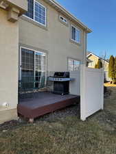 Rear view of property with a deck, a lawn, and stucco siding