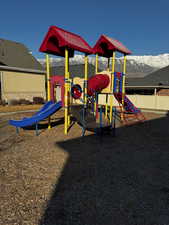 Community playground featuring a mountain view and fence