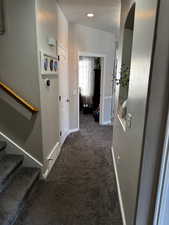 Corridor with baseboards, a textured wall, stairs, carpet flooring, and recessed lighting