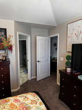 Bedroom with dark carpet, a textured ceiling, and baseboards