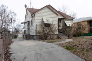 View of front of home with a gate, fence, and a tiled roof