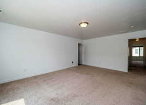 Unfurnished room with carpet floors, visible vents, a textured ceiling, and baseboards