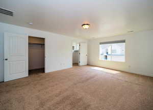 Unfurnished bedroom featuring carpet, visible vents, and baseboards