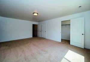 Unfurnished bedroom featuring carpet, visible vents, and baseboards