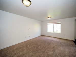 Carpeted empty room featuring visible vents and baseboards