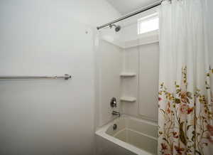 Full bath featuring shower / bath combo with shower curtain