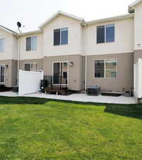 Rear view of house featuring a patio area, central AC, a lawn, and stucco siding