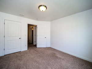 Unfurnished bedroom featuring visible vents, baseboards, and carpet flooring