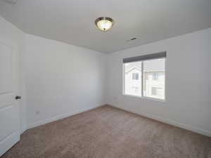 Unfurnished room featuring light colored carpet, visible vents, and baseboards