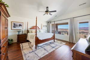 Bedroom featuring lofted ceiling, access to outside, dark wood finished floors, and visible vents