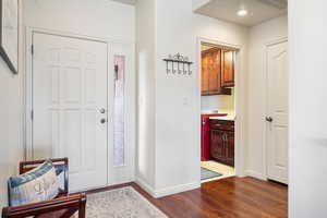 Entryway featuring dark wood-style flooring and baseboards